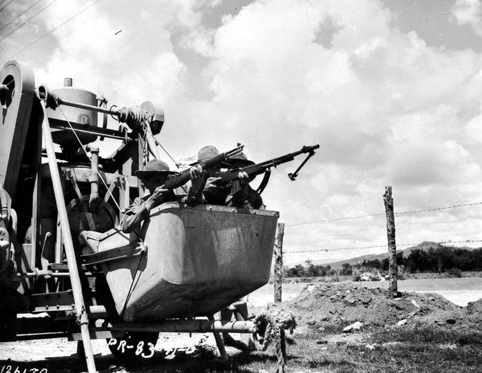 Members of Co. H, 65th Infantry, take cover in cement mixer on recent maneuvers near Salinas, Puerto Rico. November 1941.  SC 126179